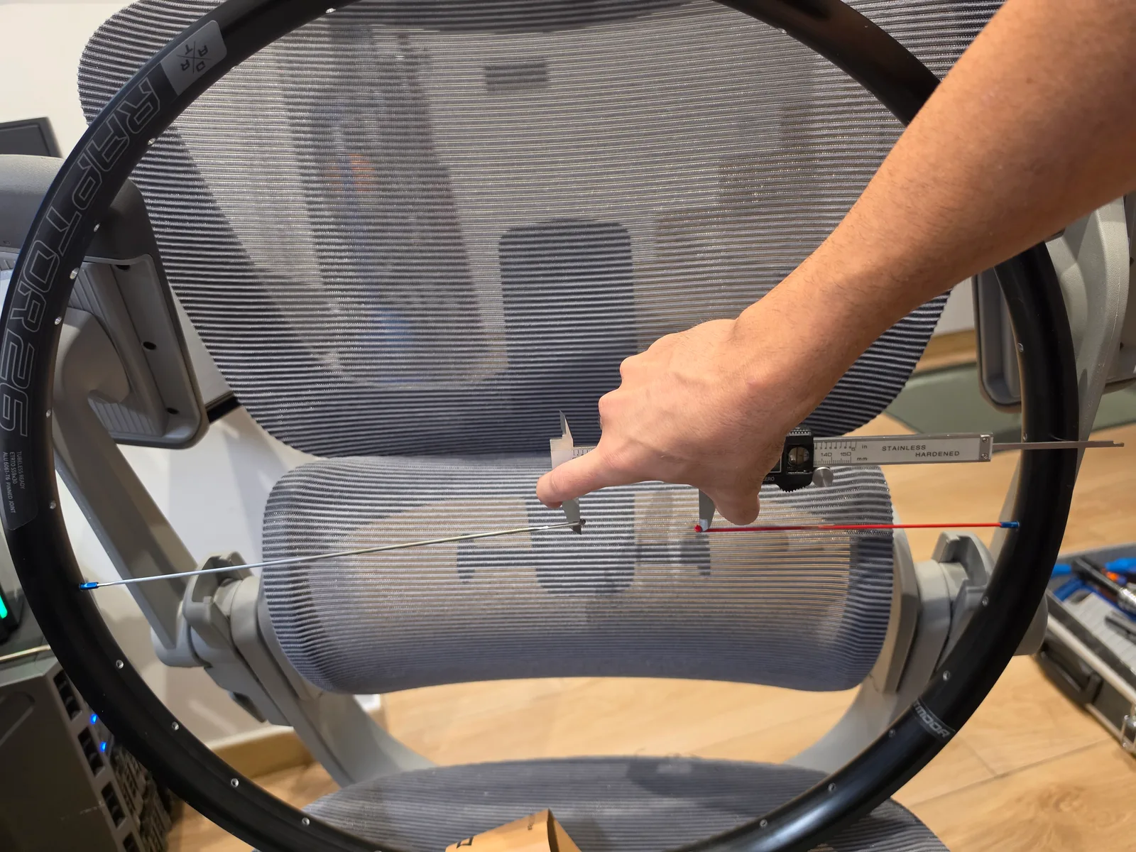 Measuring the gap between the bends of two different-length spokes fitted in a Dartmoor rim with a caliper.